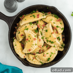 Delectable Gluten-Free Pierogi 6 Overhead view of gluten-free pierogi in a cast iron pan, with bacon and scallions on a white counter, ready to be served.