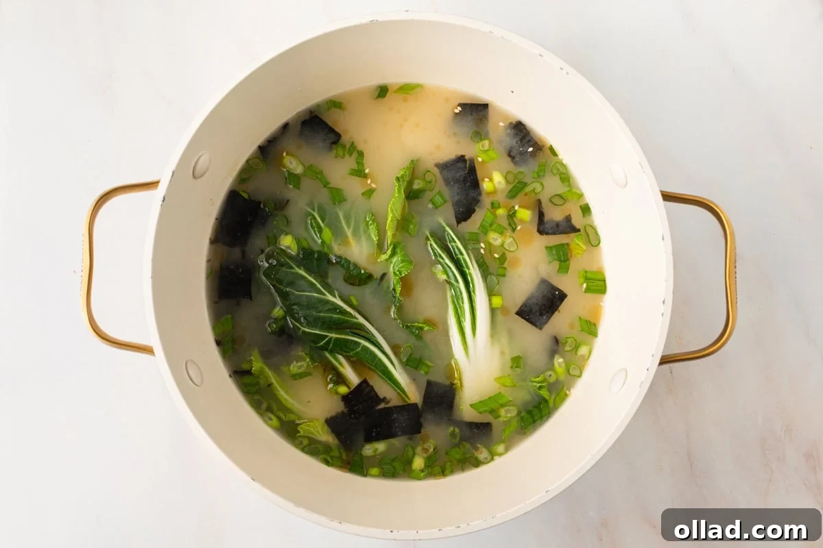 Savory Gluten-Free Miso Bowl 10 gluten-free miso soup cooking in a large pot with baby bok choy, green onions, and seaweed floating
