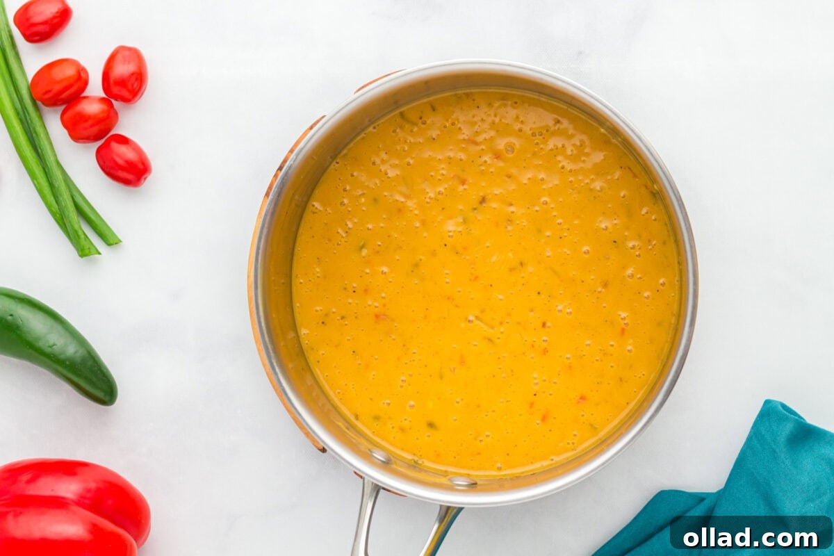 The finished, smooth, and creamy vegan queso resting warmly in a stainless steel pot, ready to be served as a delightful dip.