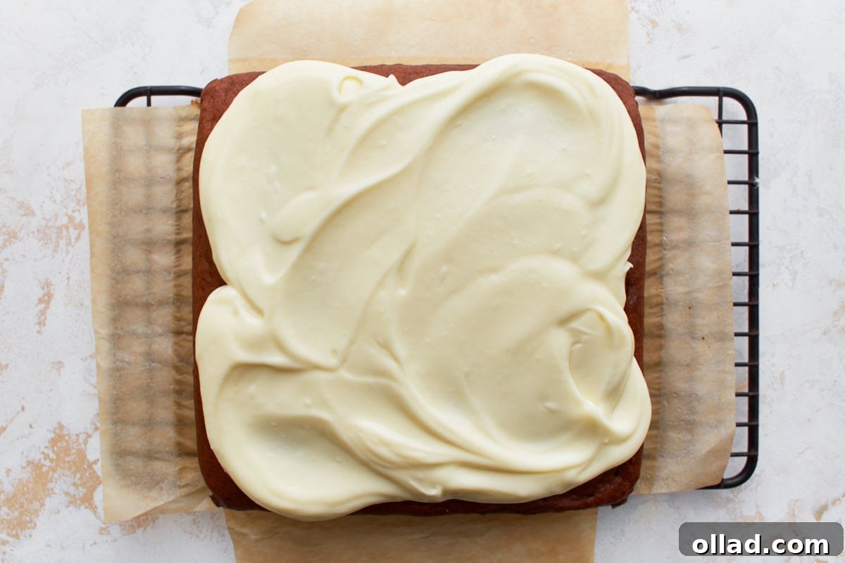 Irresistible Gluten-Free Banana Cake 10 gluten-free banana cake topped with cream cheese frosting on a cooling rack