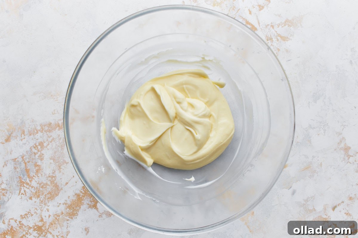 Irresistible Gluten-Free Banana Cake 9 glass bowl with cream cheese frosting mix on a light surface