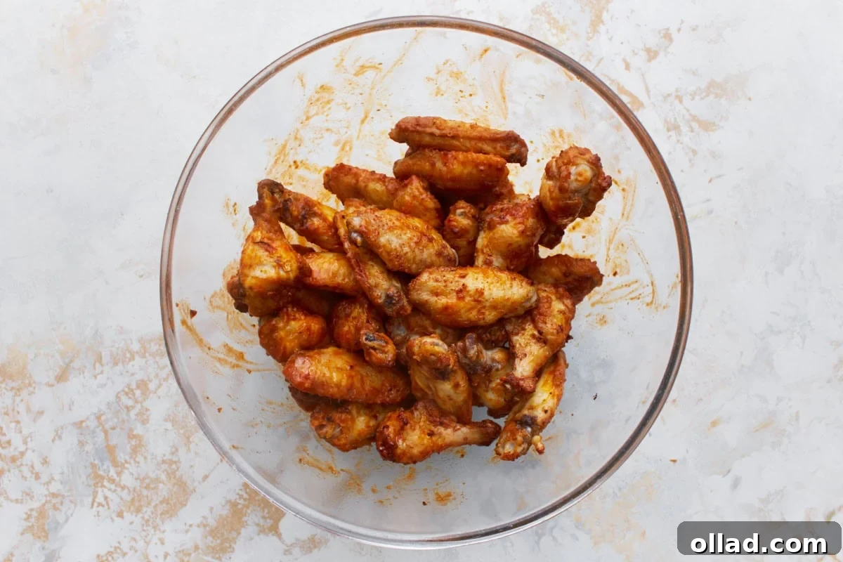gluten-free buffalo sauce coated chicken wings in a glass bowl
