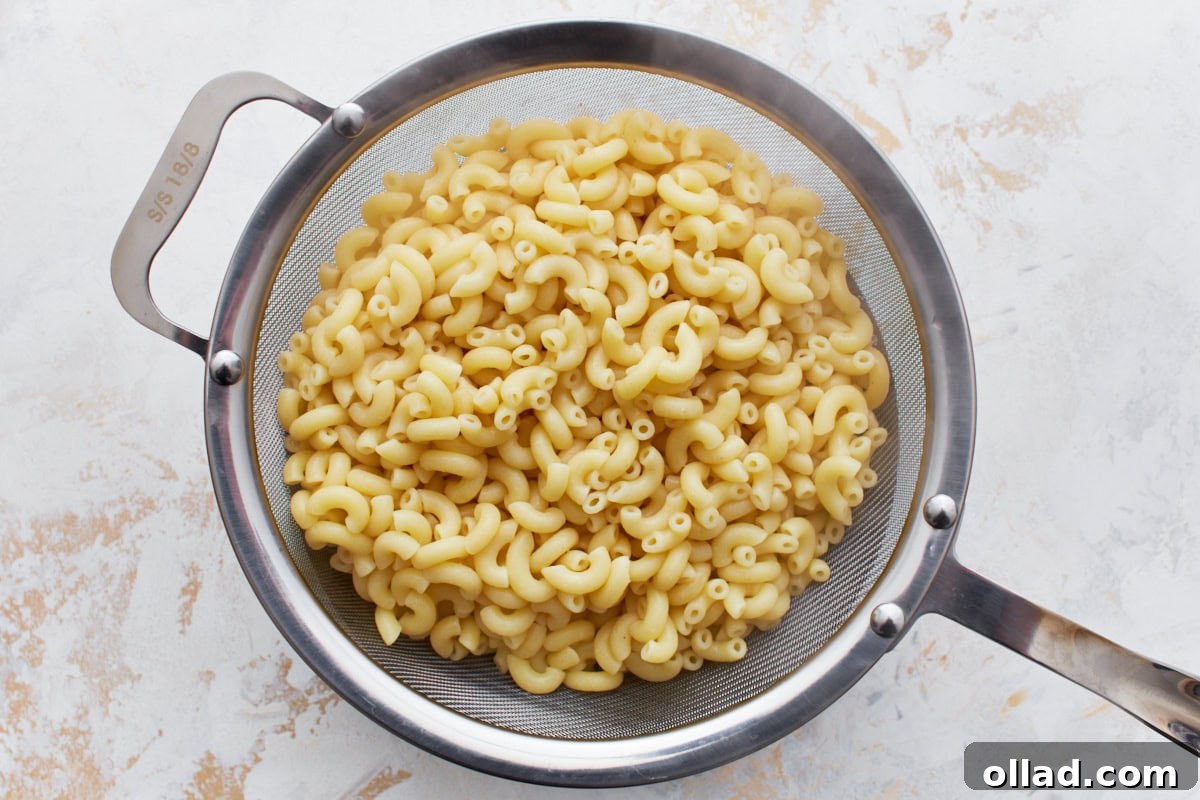 Gluten-free elbow macaroni draining in a sieve after being cooked to al dente.
