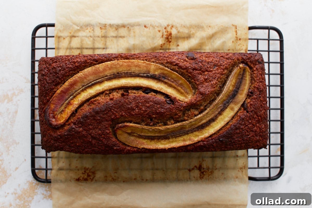 Wholesome Gluten-Free Banana Oat Loaf 10 Freshly baked banana oatmeal bread cooling on a wire rack, featuring golden brown edges and caramelized banana slices on top.