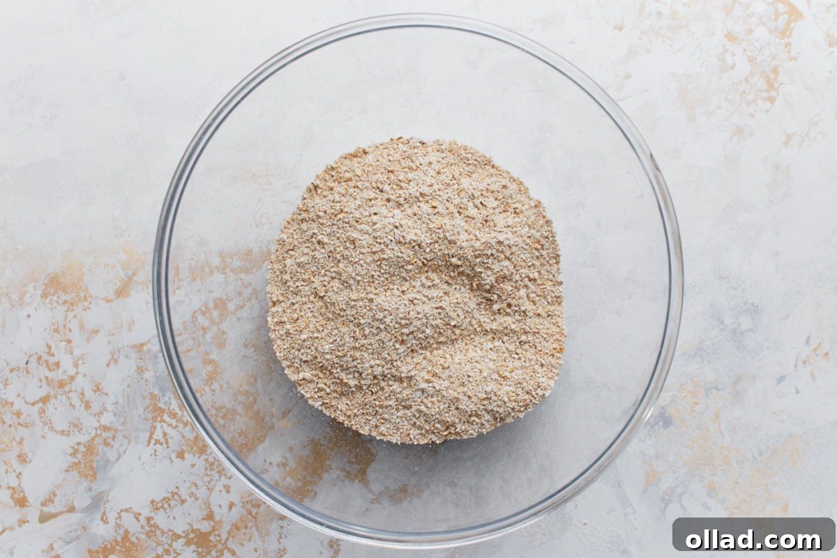 Wholesome Gluten-Free Banana Oat Loaf 6 Coarse oat flour and other dry ingredients mixed together in a glass bowl