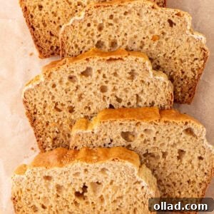 Overhead view of several slices of cassava bread arranged on parchment paper, showing a golden crust and airy crumb.