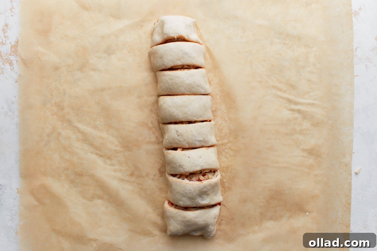 Irresistible Gluten-Free Pizza Poppers 10 Rolled dough sliced into even pieces to form individual pizza rolls before baking.