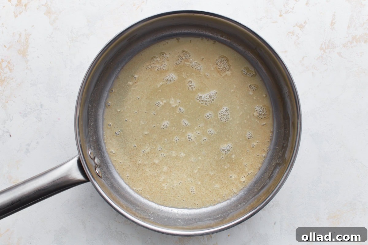 A saucepan with a light golden gluten-free roux made from oil and flour bubbling gently.