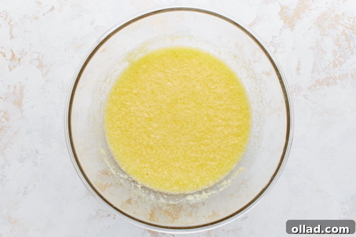 Gluten-Free Zesty Lemon Glaze Loaf 5 Wet ingredients, including lemon zest and butter, combined in a mixing bowl.
