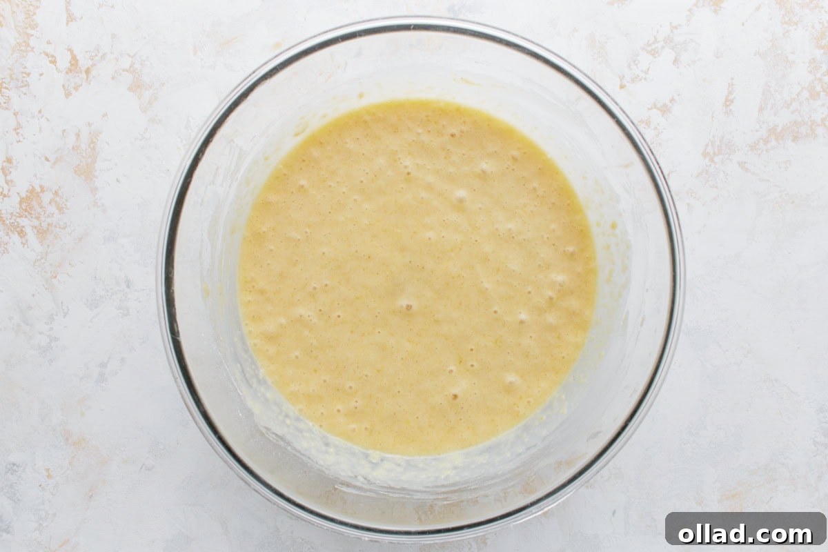 Gluten-Free Zesty Lemon Glaze Loaf 6 Fully mixed lemon loaf batter in a glass bowl, smooth and ready to pour.