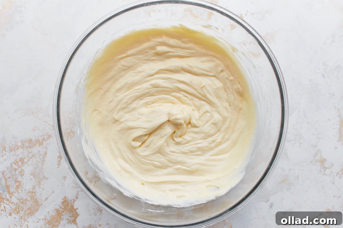 Keto cheesecake filling after eggs, vanilla, lemon juice, and sour cream have been mixed in.