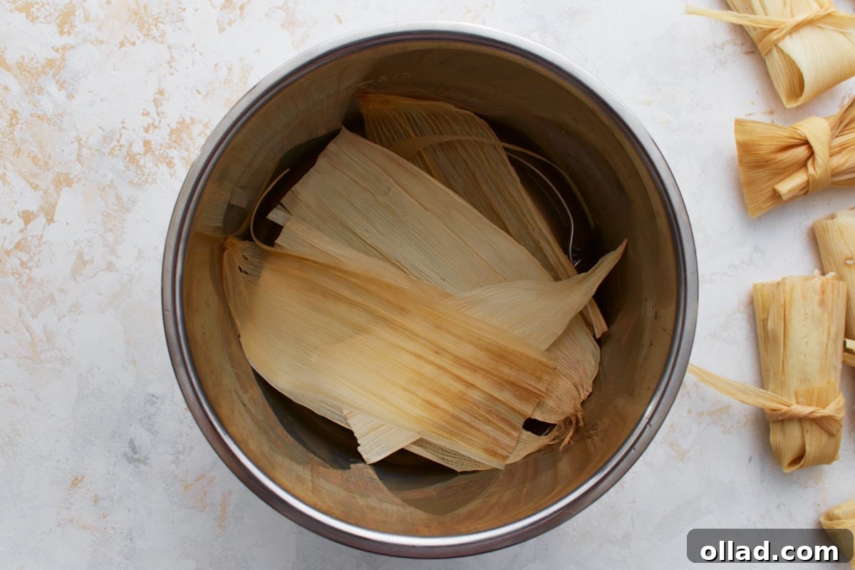 A few soaked corn husks placed at the bottom of a metal pot to line the steamer.