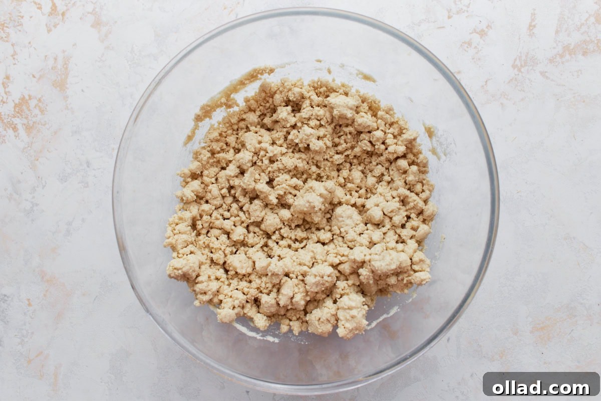 The masa mixture after adding melted lard, crumbly and starting to come together.