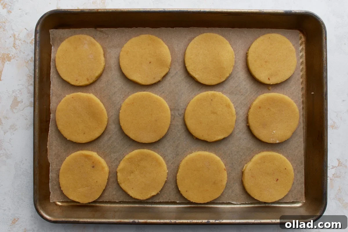 Unbaked almond flour sugar cookies arranged evenly on a parchment-lined baking sheet.