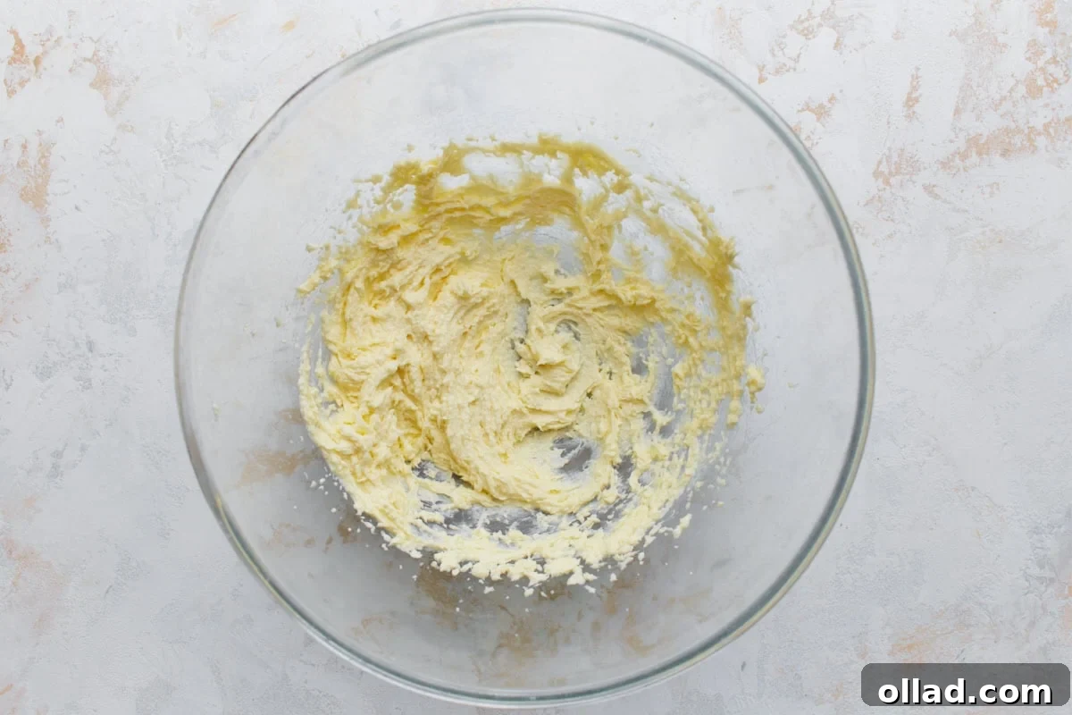 Creamed butter and sugar mixture in a glass bowl for almond flour sugar cookie dough.