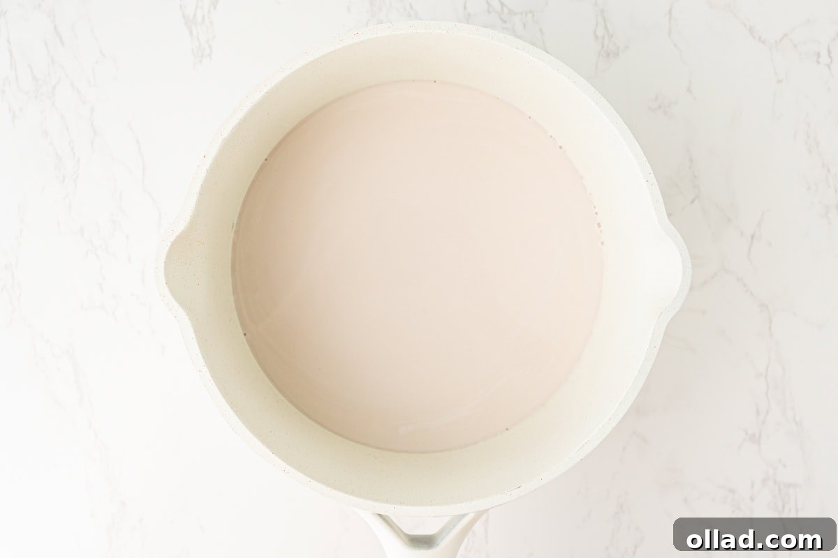 Warm coconut milk mixture resting in a saucepan after heating.