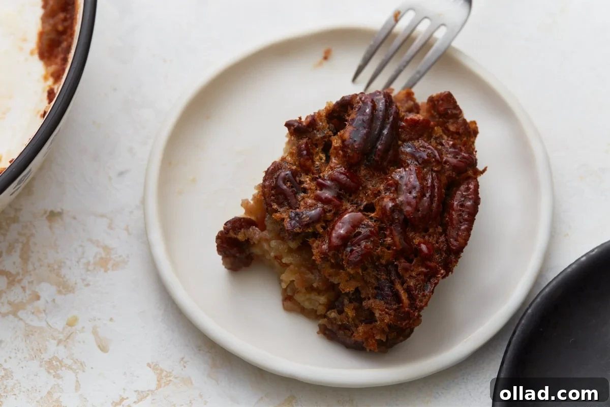 slice of crustless pecan pie on a plate with a fork being dipped into it