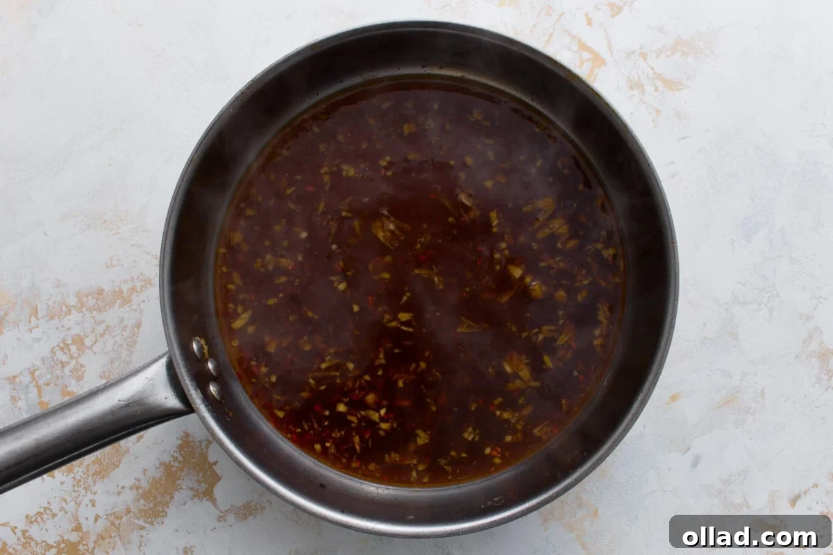 Gluten-free General Tso’s sauce simmering in a skillet before thickening