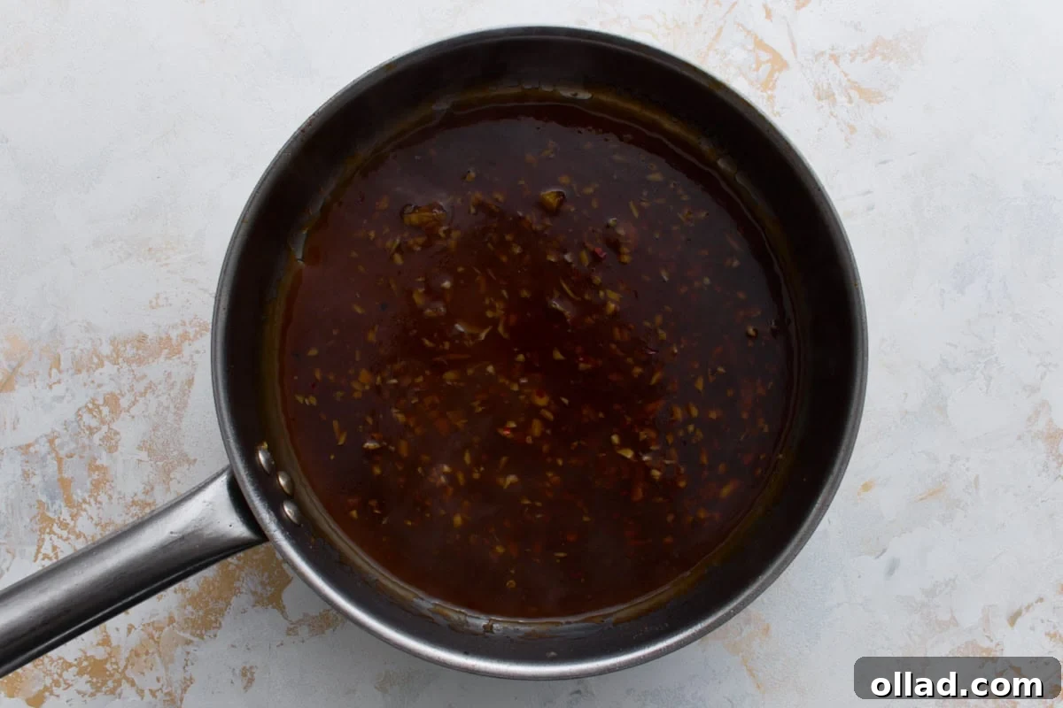 Gluten-free General Tso’s sauce simmering in a skillet until thickened and glossy
