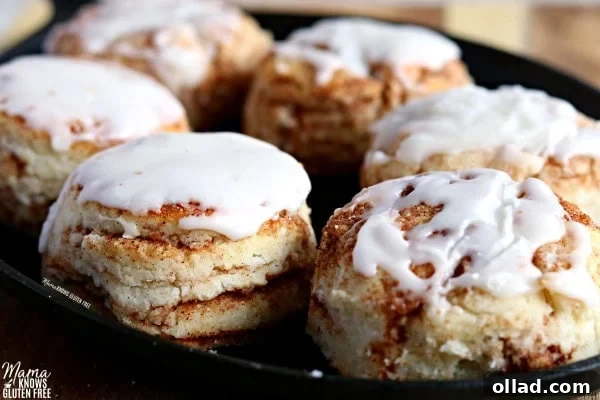 Warm Spiced Gluten-Free Biscuits, Dairy-Free Friendly 6 Six glazed gluten-free cinnamon biscuits arranged neatly in a cast iron pan, showcasing their golden-brown tops and sweet vanilla drizzle, ready to be enjoyed.