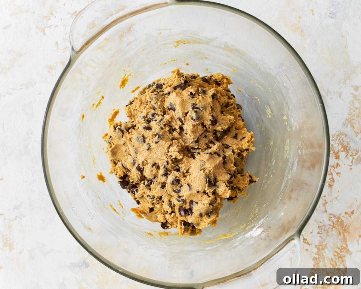 Chocolate chip cookie dough for gluten-free chocolate chip cookies in a glass mixing bowl