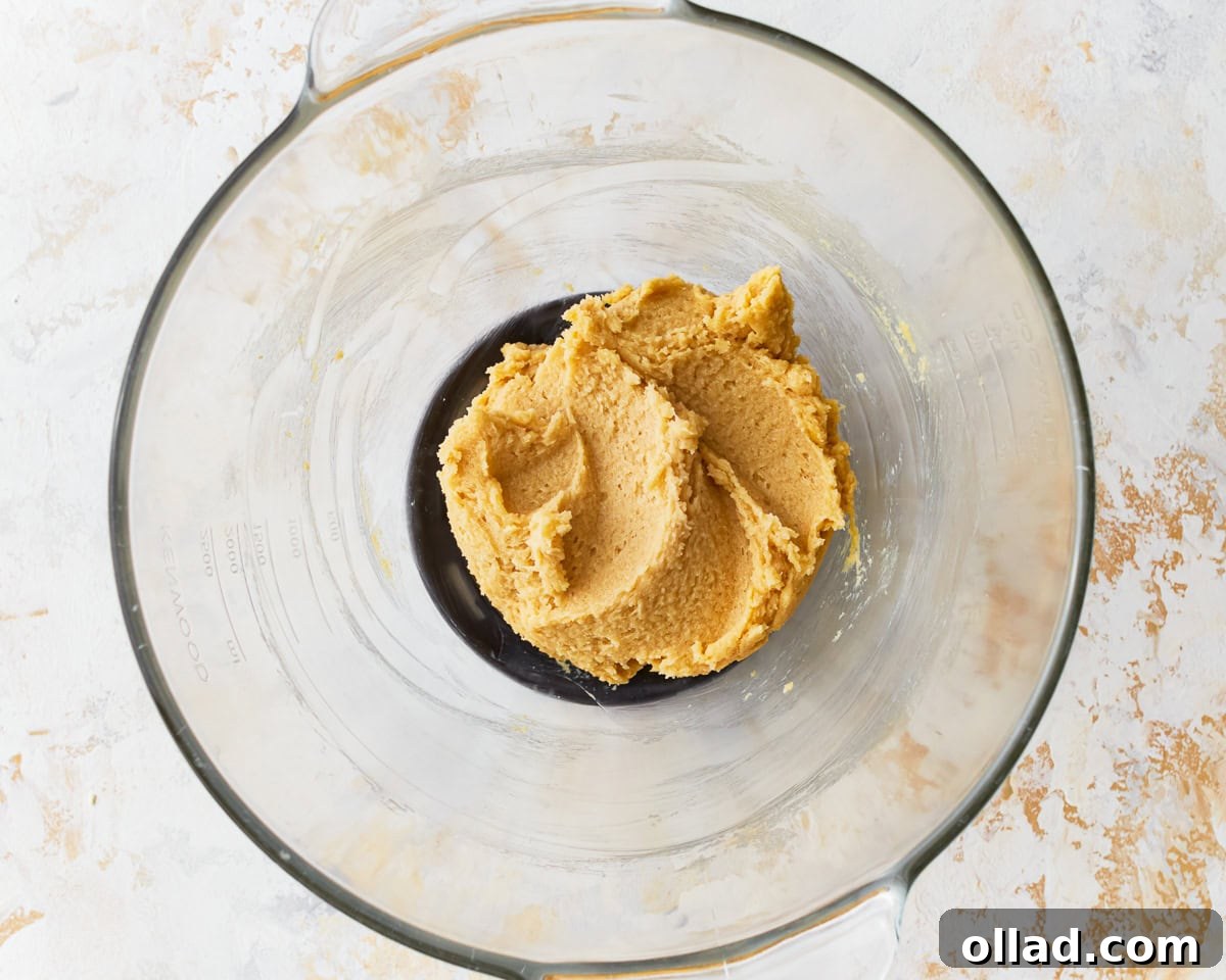 Softened butter and sugar mixture in a glass mixing bowl