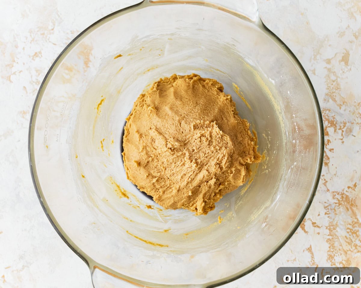 Cookie dough for gluten-free chocolate chip cookies in a glass mixing bowl