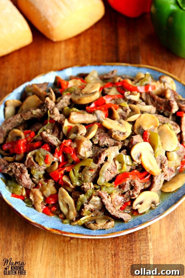 A blue plate filled with cooked sliced steak, vibrant bell peppers, mushrooms, and onions, ready to be served.