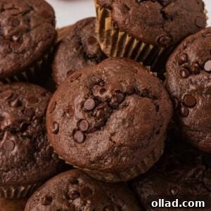 Close-up of a stack of gluten-free double chocolate muffins topped with melty chocolate chips.