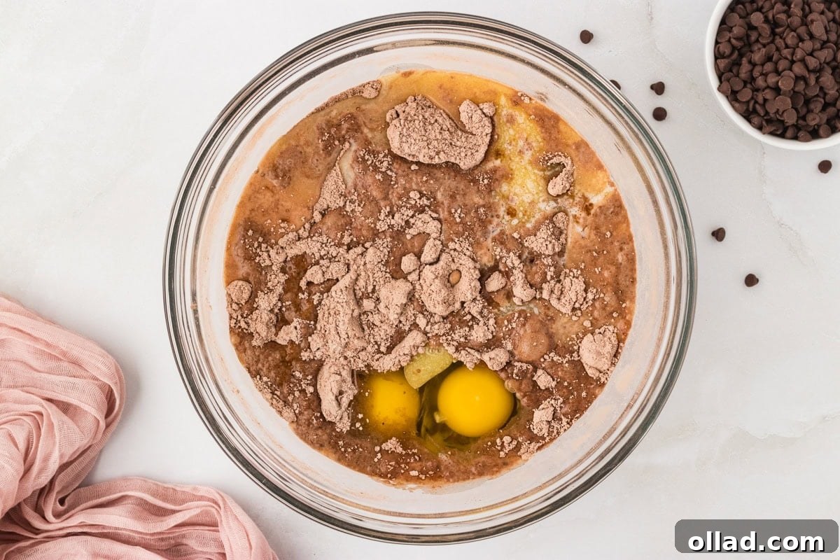 Decadent Gluten-Free Double Chocolate Muffins 6 Glass mixing bowl with wet and dry muffin ingredients, including room temperature eggs, cocoa powder, and melted butter, just before the final mix.