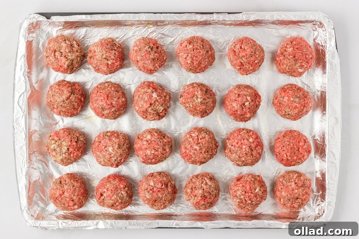 Delicious Gluten-Free Meatballs 10 Evenly spaced raw gluten-free meatballs lined up on a foil-covered baking sheet, ready to go into the oven.
