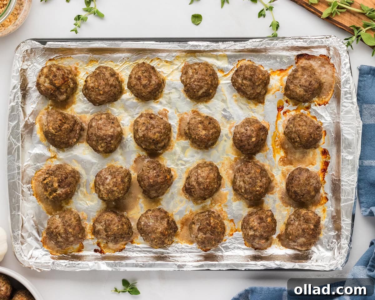 Delicious Gluten-Free Meatballs 11 Freshly baked gluten-free meatballs on a foil-lined sheet pan, golden and cooked through.