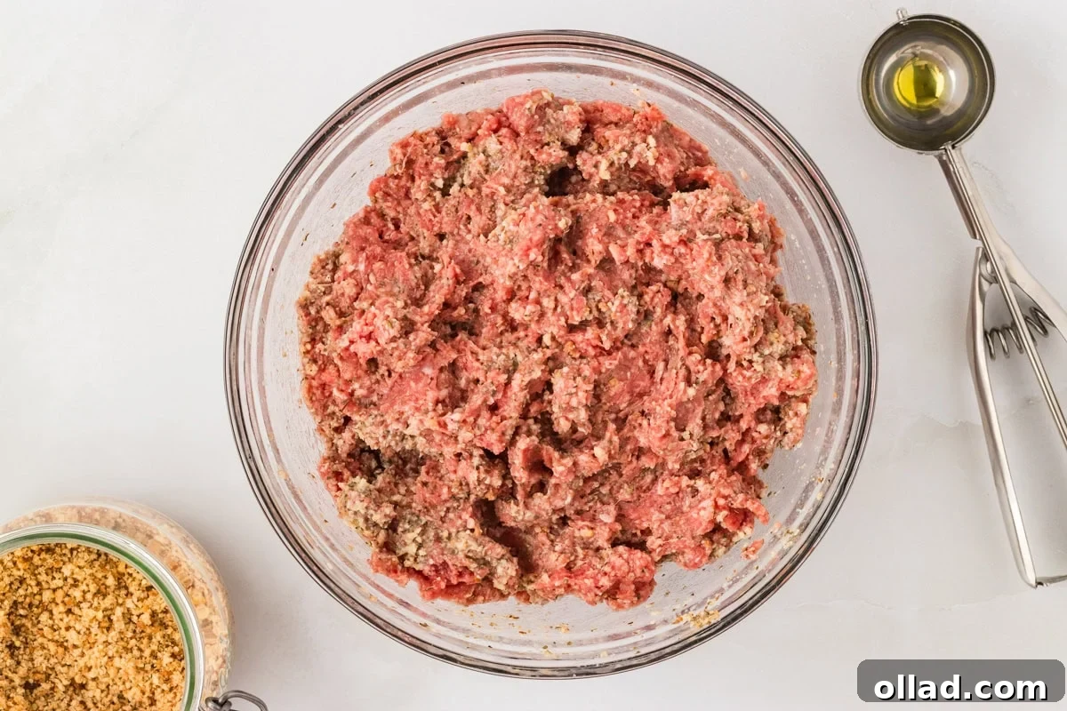 Delicious Gluten-Free Meatballs 8 Ground beef mixed with gluten-free breadcrumb mixture in a glass bowl, ready to shape into meatballs.
