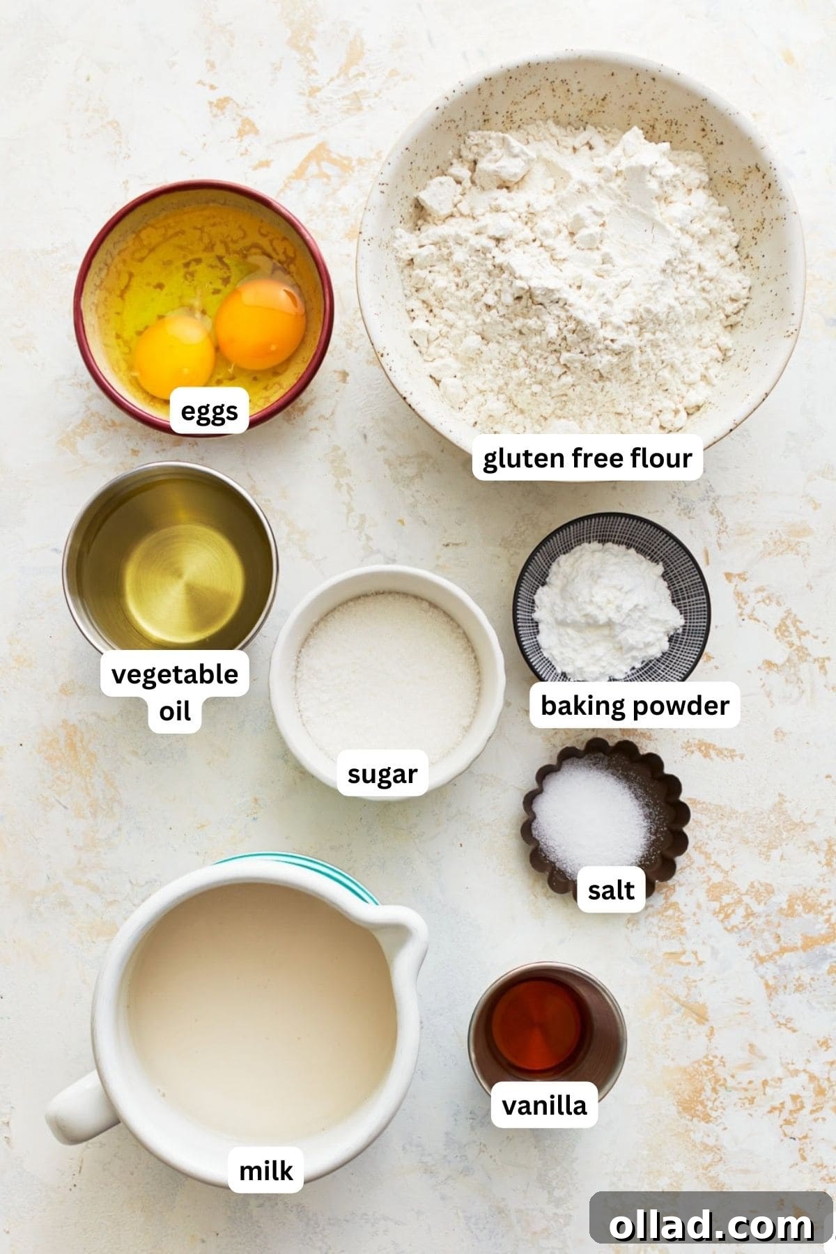 A simple yet elegant flat lay of all the dry and wet ingredients laid out neatly for making gluten-free waffles, highlighting their freshness and readiness for mixing.