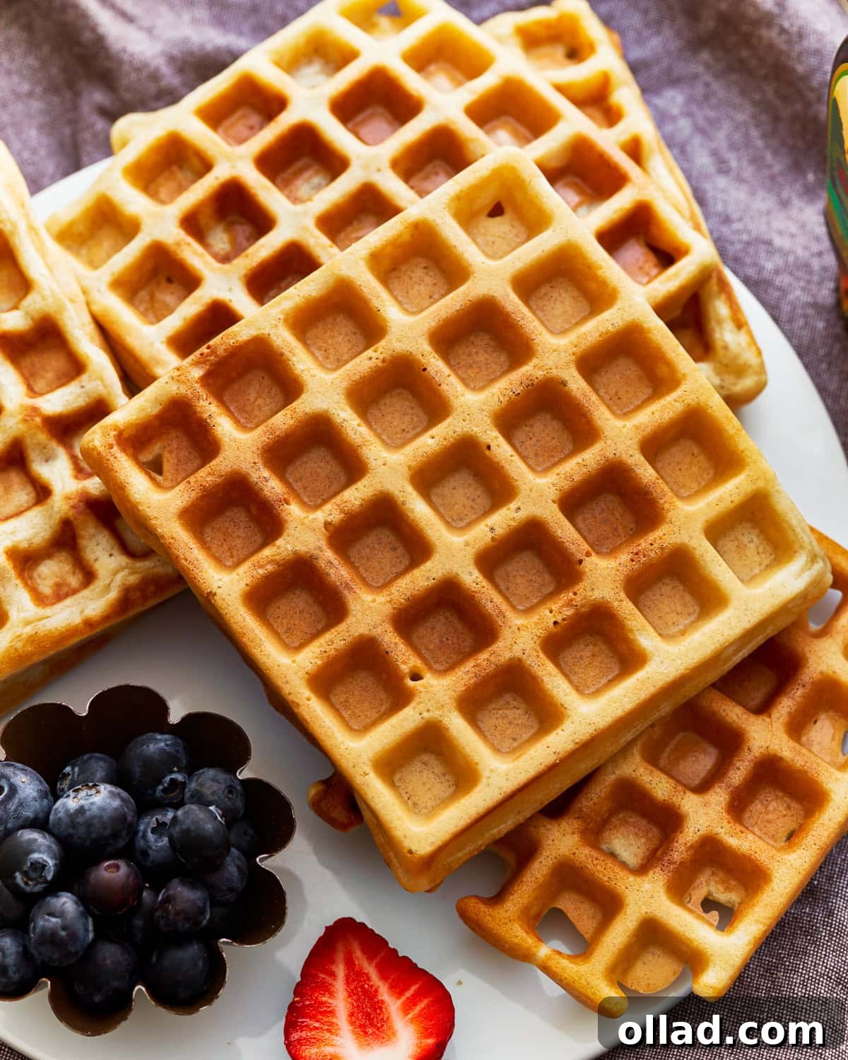 A stack of golden gluten-free waffles, ready to be enjoyed, possibly with a hint of steam rising, indicating freshness.