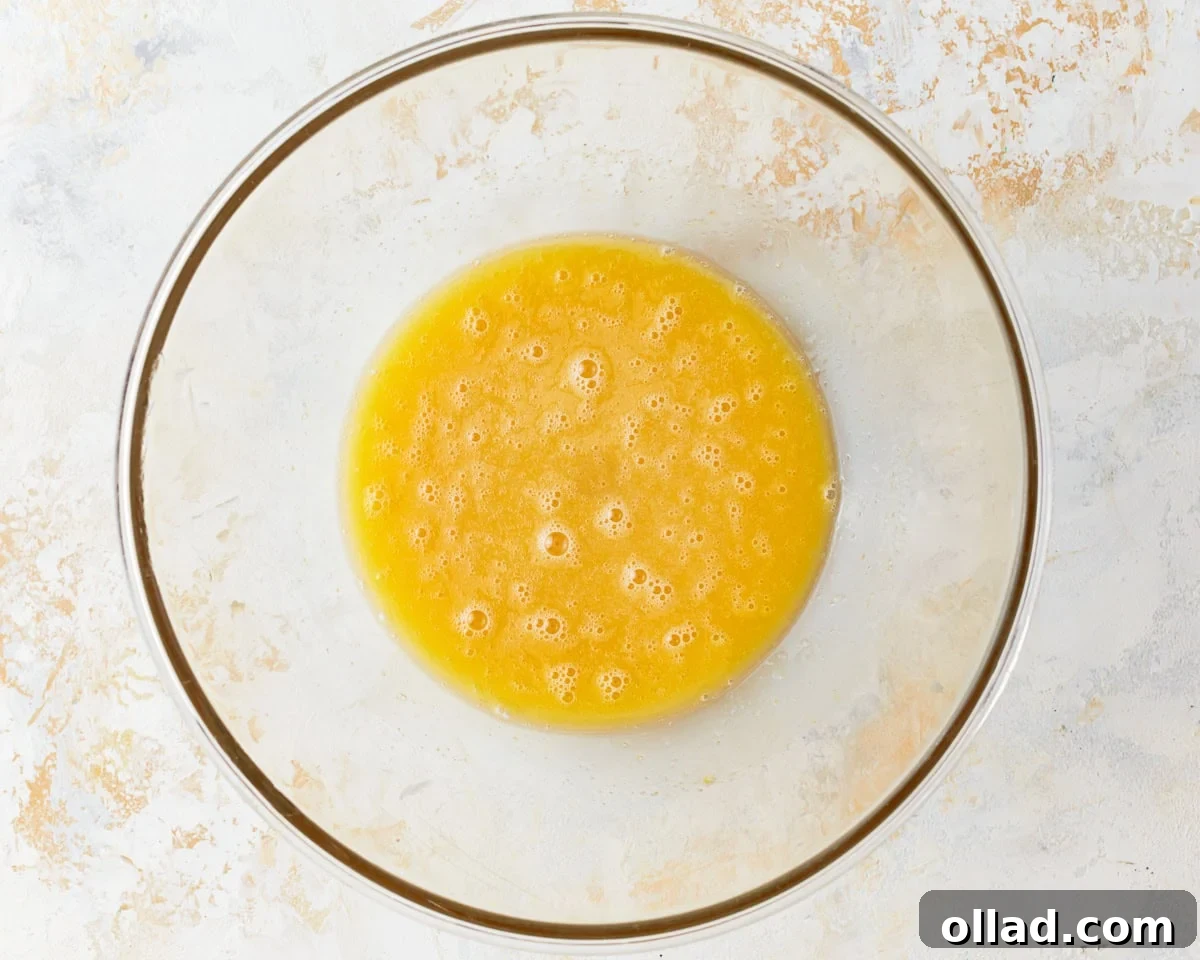 Two large eggs in a clear glass bowl, ready to be whisked, demonstrating the first step of the recipe.