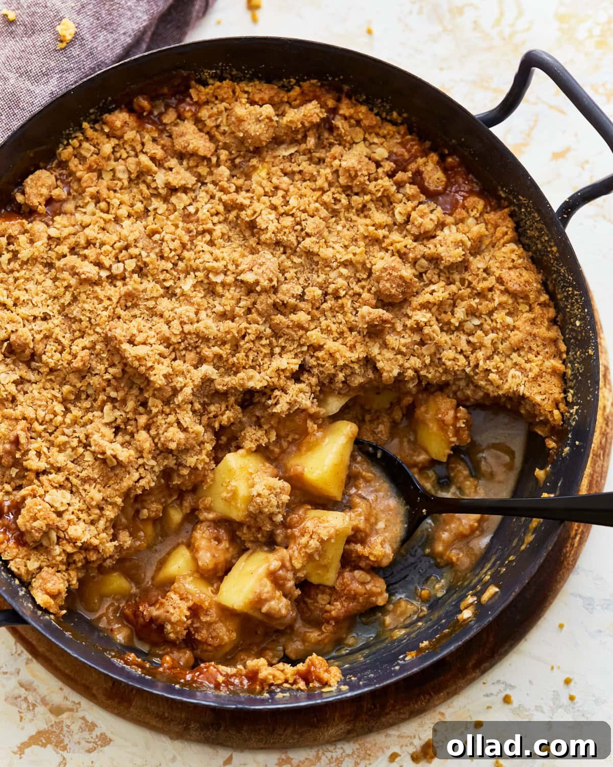 Wholesome Gluten-Free Apple Crumble 2 A golden-brown gluten-free apple crisp in a white baking dish, ready to be served, topped with a scoop of vanilla ice cream and a drizzle of caramel sauce, highlighting the crunchy oat topping and soft apple filling.