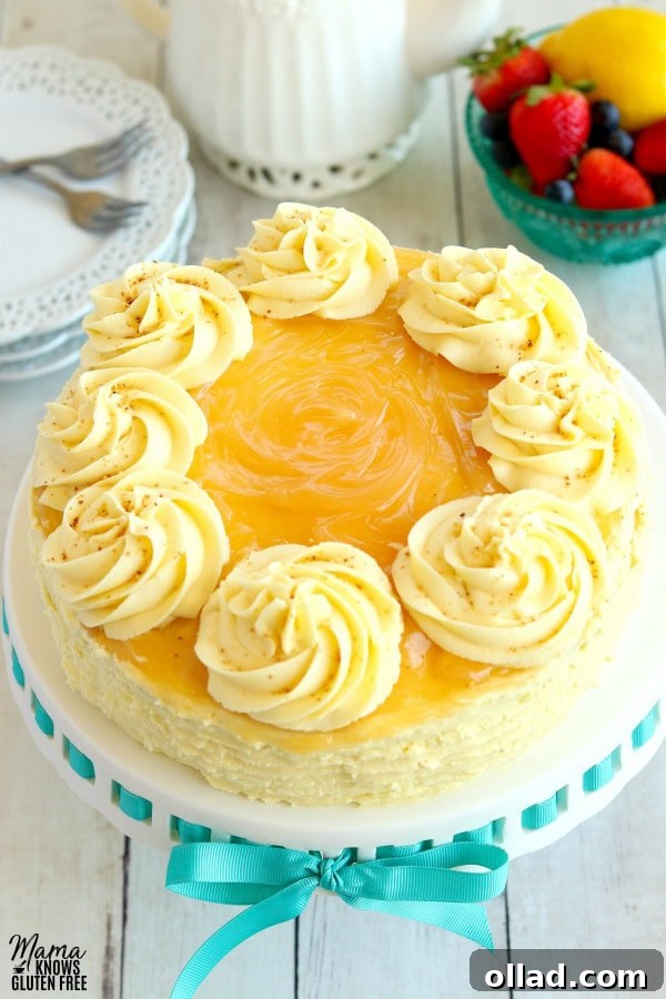 lemon cake with lemon buttercream frosting with berries, lemon, tea pot and plates in the background