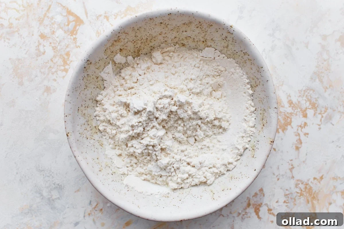 Cloud-Light Gluten-Free Angel Food Cake 5 Gluten-free flour and cornstarch being thoroughly mixed together in a pristine white bowl.