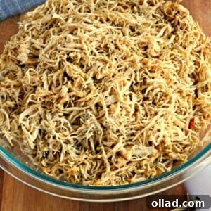 A generous serving of succulent rotisserie-style shredded chicken, highlighting its tender texture and rich, golden color, ready to be enjoyed or incorporated into other dishes.