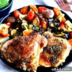 A close-up shot of perfectly cooked crispy chicken thighs, golden brown and glistening, with visible seasoning on the skin. The focus is on the delicious texture and rich color of the chicken.