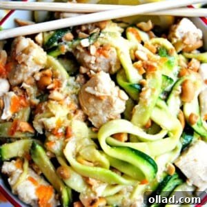 A inviting bowl of honey lemon ginger chicken zoodles, beautifully garnished with fresh lemon slices and a pair of elegant chopsticks. The dish showcases tender chicken and vibrant zucchini noodles coated in a zesty glaze.