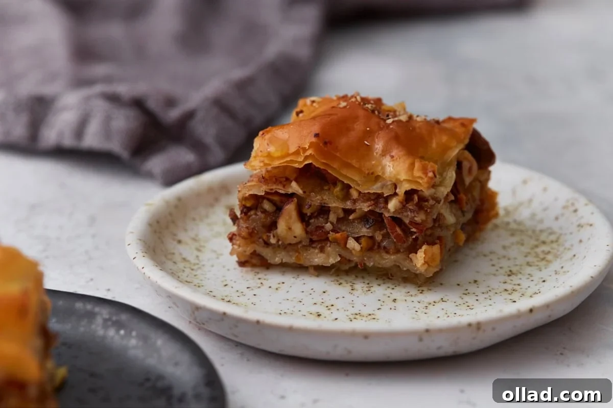 Piece of gluten-free baklava served on a small plate showing the layered nut filling and crisp phyllo pastry.