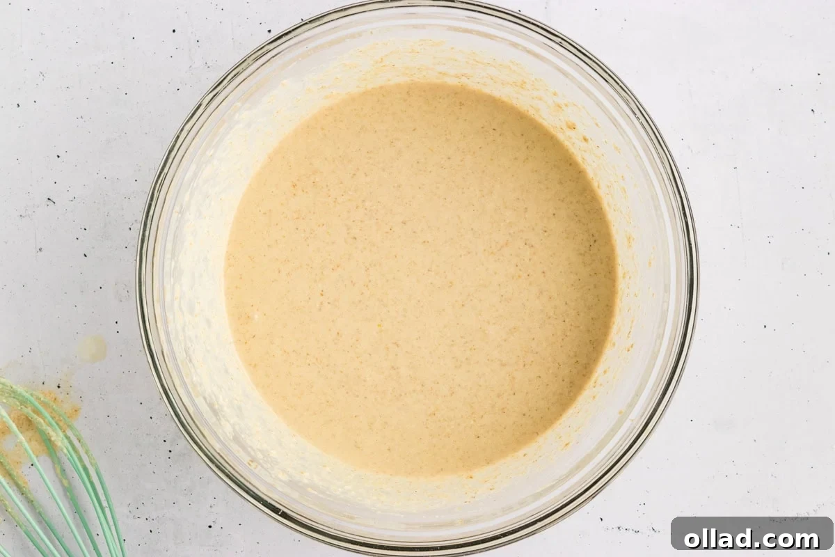 Smooth, thick oat flour pancake batter in a glass mixing bowl.
