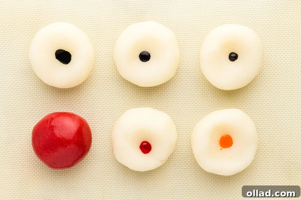 six white dough rounds, each with a drop of gel food coloring in the center before kneading