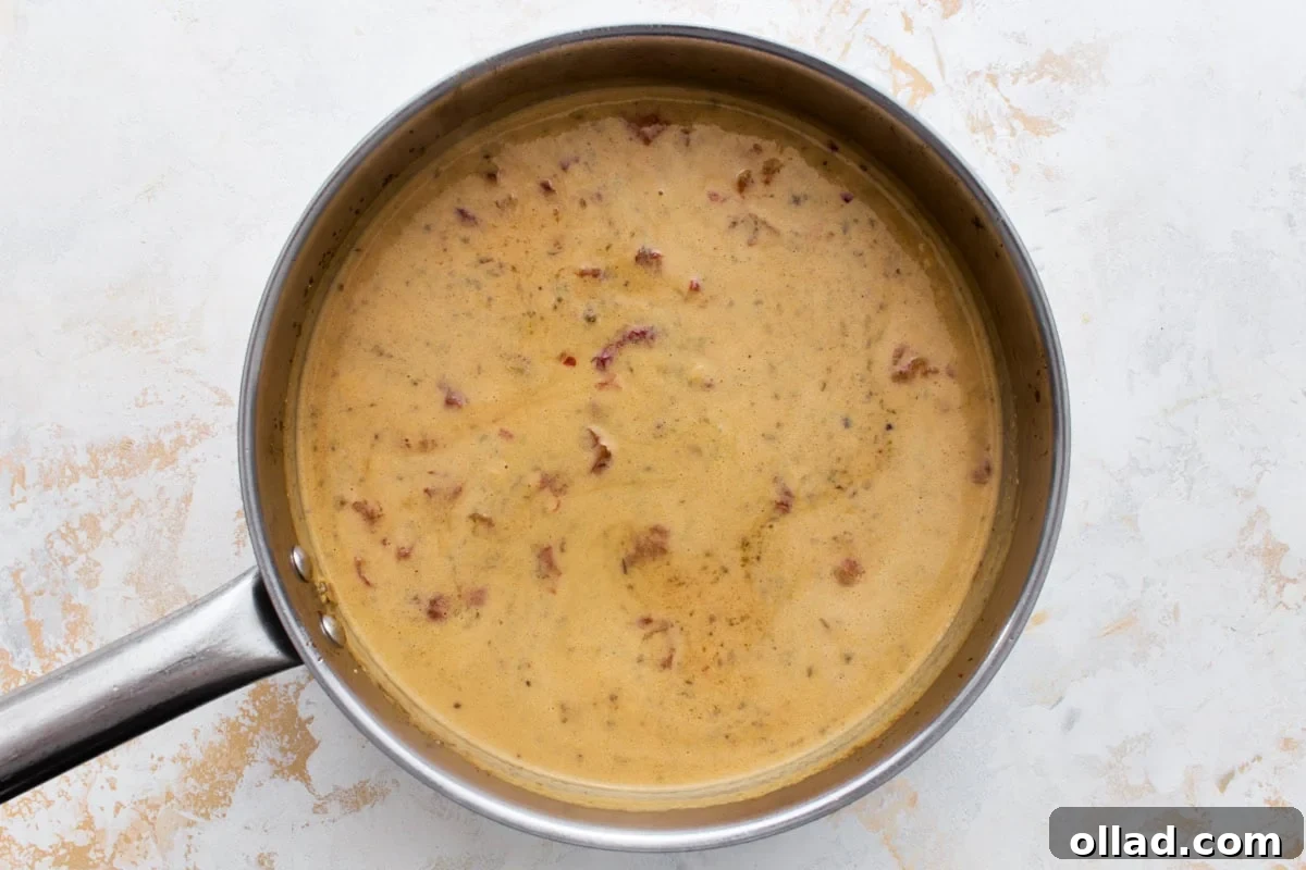 Creamy dairy-free Marry Me Chicken sauce simmering in a skillet until thickened, before the chicken is added back.