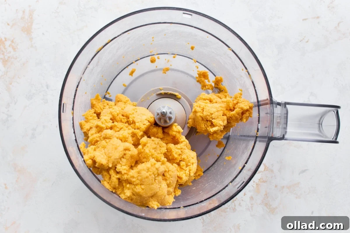 Gluten-free goldfish cracker dough clumped together in a food processor after adding cold water.