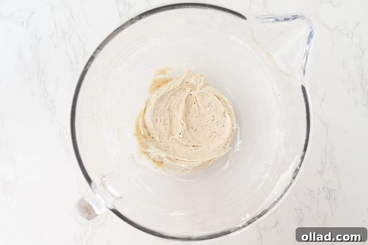 Brown butter cream cheese frosting whipped smooth in a stand mixer bowl.