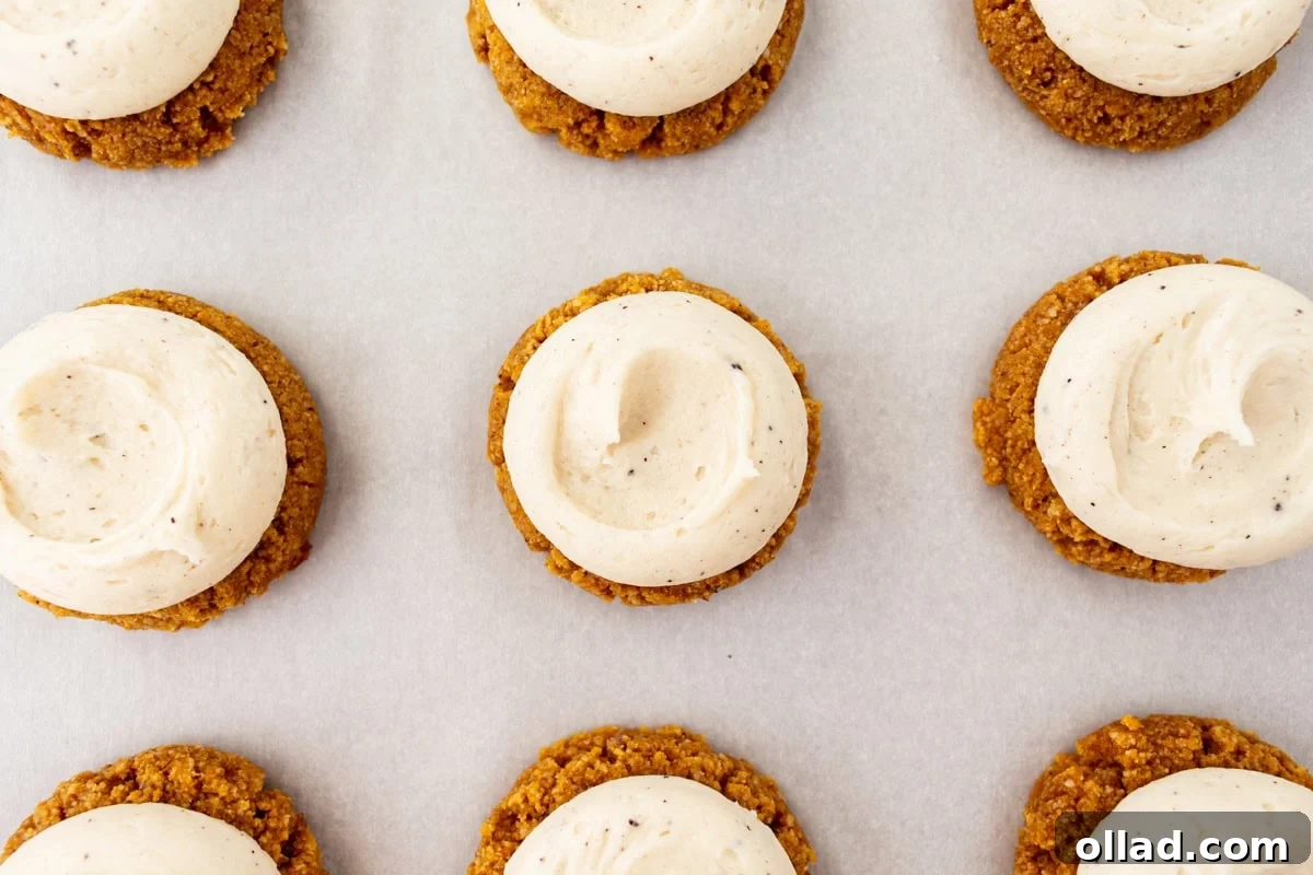 Overhead view of gluten-free almond flour pumpkin cookies topped with brown butter cream cheese frosting.
