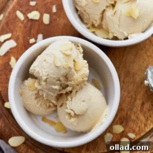 Close-up of creamy almond milk ice cream scooped into a white ramekin, topped with sliced almonds.